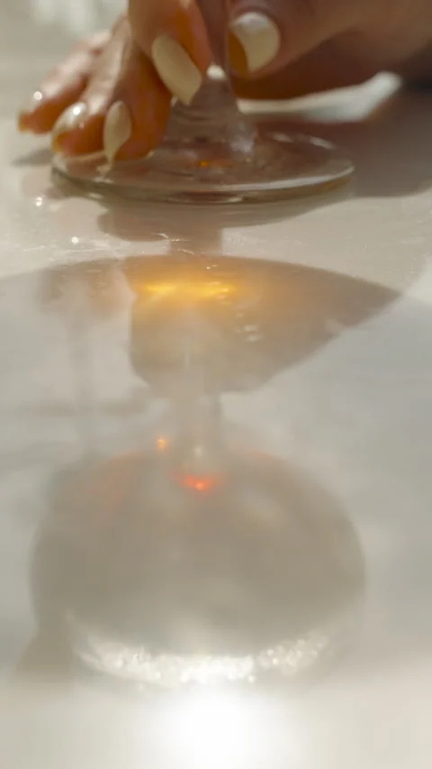 Vertical video. Extreme close up of cocktail glass base casting circular light Video stock 313237073