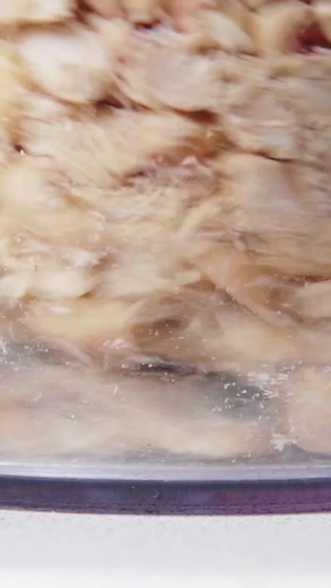 Vertical video extreme close up of peanuts rotating fast inside food processor Stock Footage 345212094