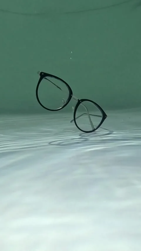 Vertical video Eyeglasses falling and sinking underwater. glasses at the bottom Video stock 286900029
