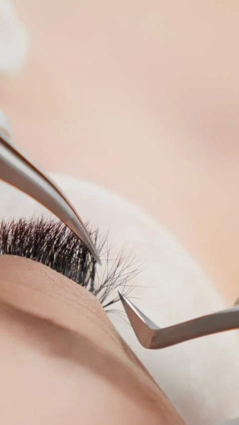 Vertical video eyelash extensions process includes applying individual lashes Stock Footage 277908181