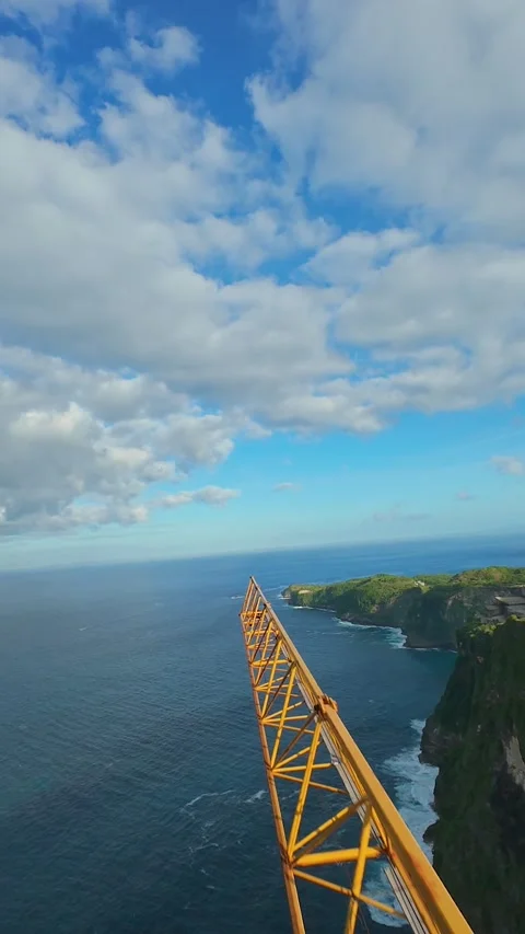 Vertical video. Fast FPV Drone Flight Along Construction Crane At Kelingking Bea Stock Footage 336633699