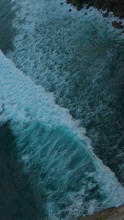 Vertical video. Fast FPV Drone Dive Toward Breaking Waves Below Coastal Cliffs W Stock Footage 336643529