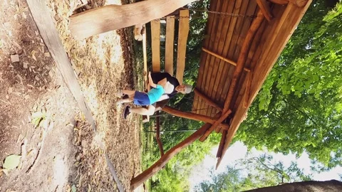 Vertical video - father and son swing on a swing. Rest, emotions, leisure, play Stock Footage 246644079