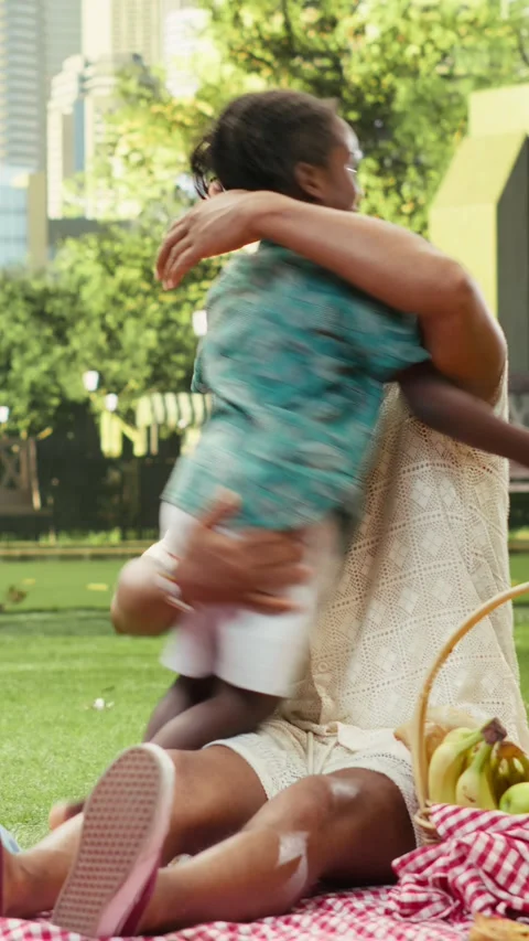 Vertical Video Father lifting and hugging boy while mother laughs on checkered Stock Footage 341471057