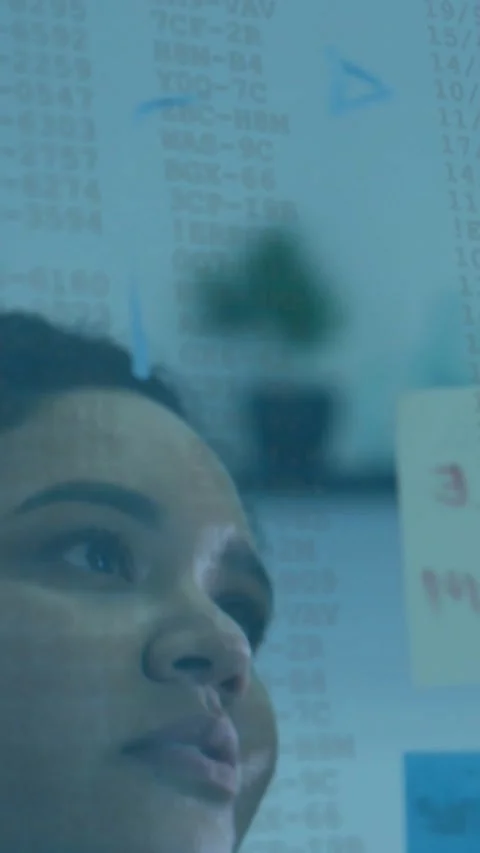 Vertical video: Female analyst checking data, pointing glass board, adding red Stock Footage 331167078