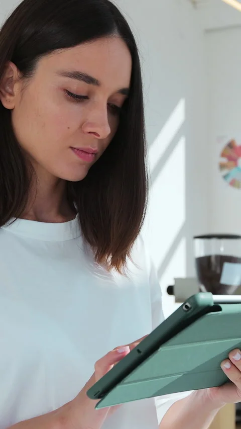 Vertical video. Female barista using digital tablet in cafe, checking Stock-Footage 343766811