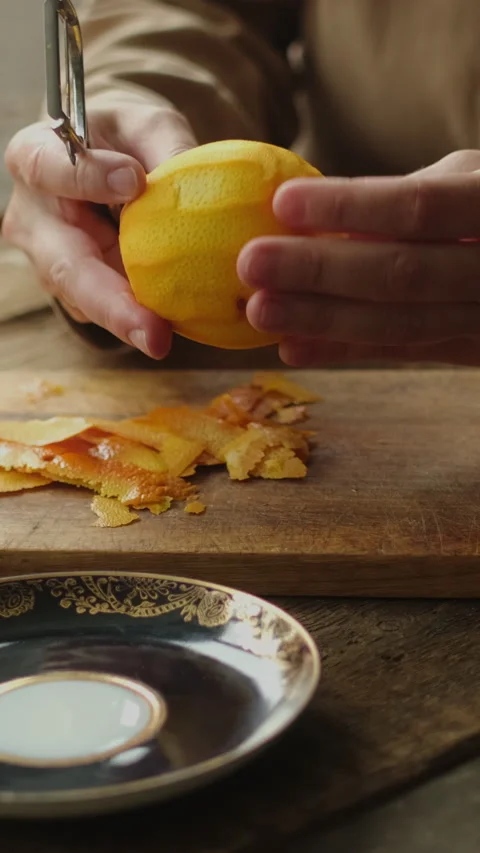 Vertical video. Female hands peeling fresh orange zest Stock Footage 334429758