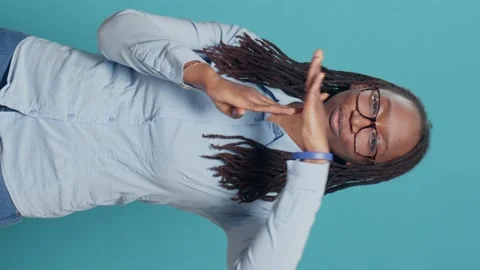 Vertical video: Female model doing timeout pause gesture on camera Stock Footage 210882957