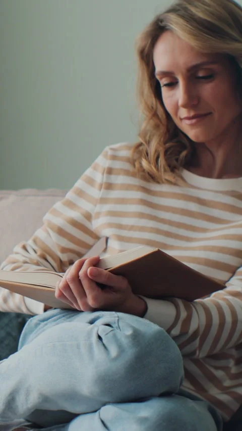 Vertical video. Female or student enjoying entertainment literature Stockbeeldmateriaal 343764627