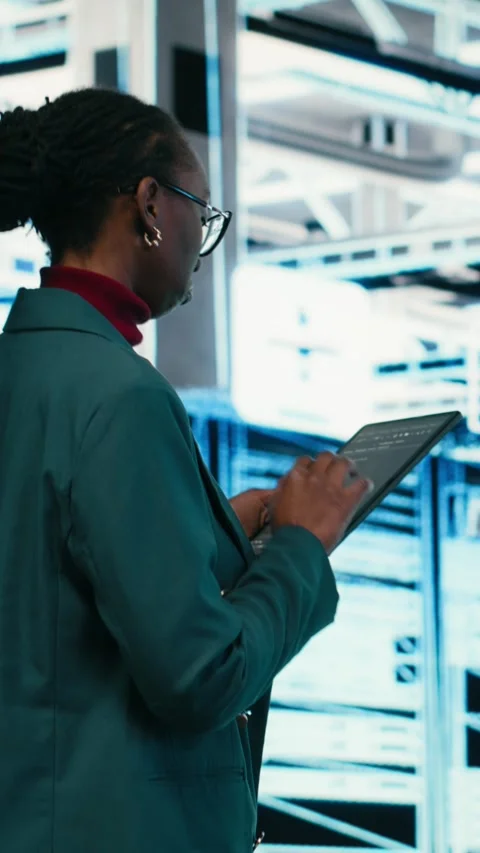 Vertical video Female programmer walking in data center using tablet to write Stock-Footage 329590773
