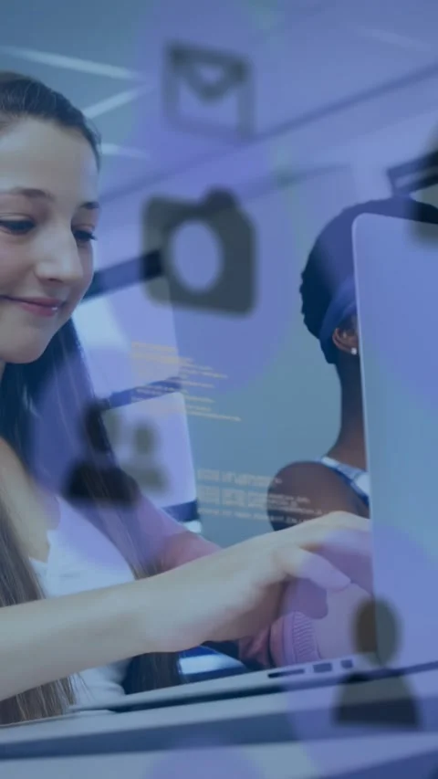 Vertical video: Female student typing at laptop in class, causing icons and code Stock Footage 330195838