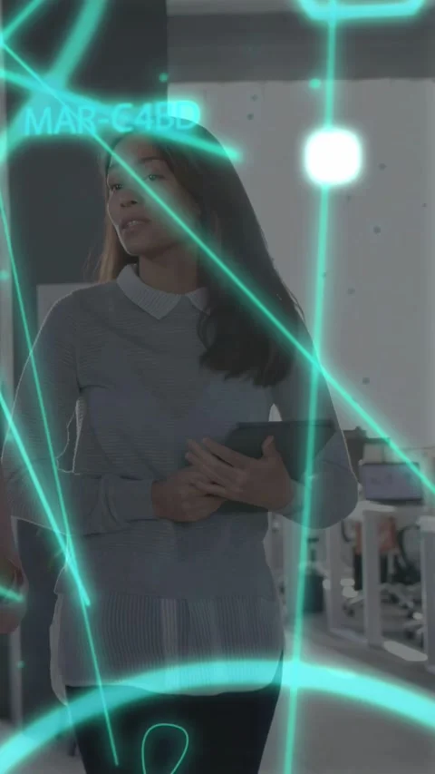 Vertical video: Female tech pro entering frame with tablet, holo UI crossing Stock Footage 333978368