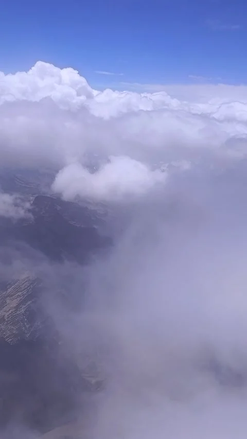 Vertical Video: Fight above clouds with mountains covered with snow. Stock Footage 263760951