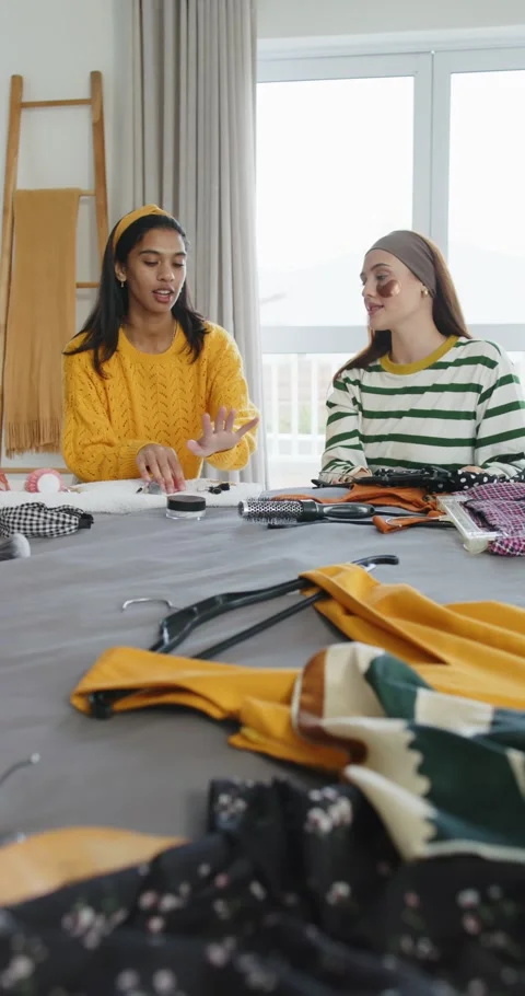 Vertical video: Finding polka-dot dress, diverse women sitting at table by Stock Footage 345092781