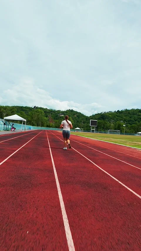 Vertical video. First Person FPV Drone Following a Woman Running Along a Stadium Stock Footage 338188750