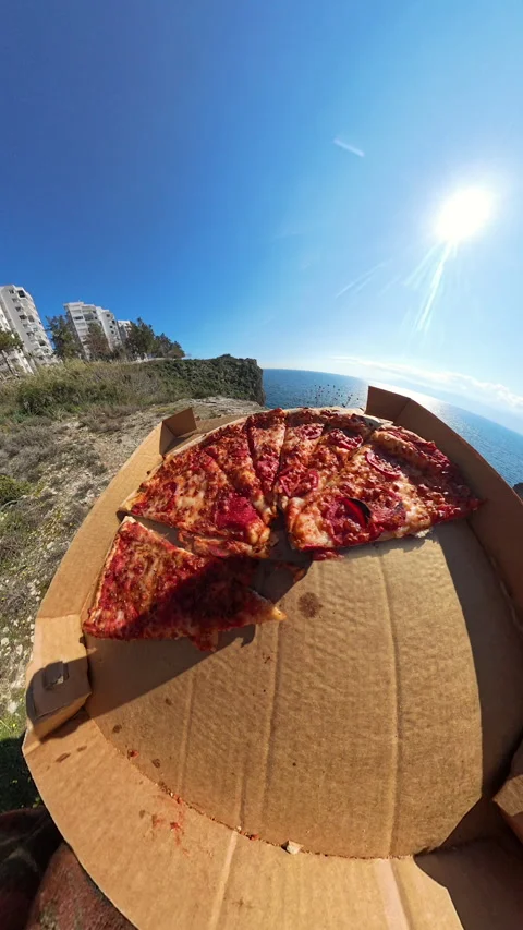 Vertical video. First-Person View of a Pizza Box Held Over a Cliff with a Tiny Stock Footage 304284469