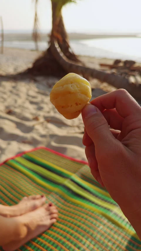Vertical video. First Person View Of Hand Holding Mini Pineapple Piece Against S Stock Footage 332296826