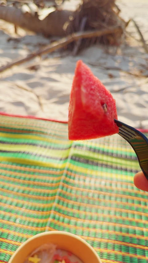 Vertical video. First Person View Of Fork Holding Watermelon Slice Over Colorful Stock Footage 332300660