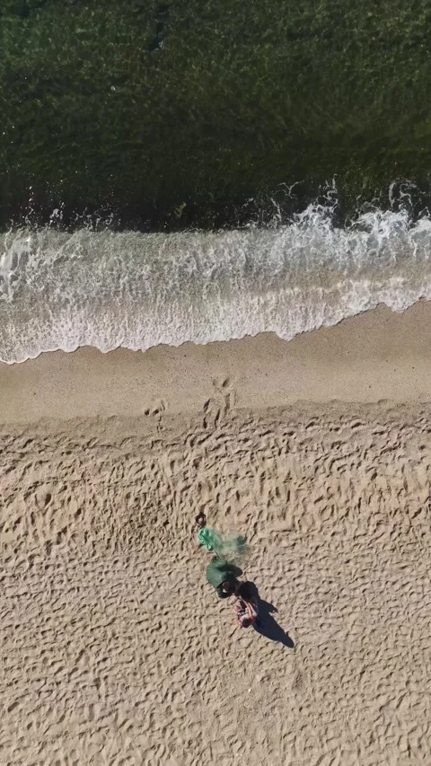 Vertical Video of a Fisherman Throwing a Net Into Turquoise Waters With Gentle Stock Footage 300344645