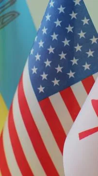 Vertical video. Flags of Various Countries on Table. Stock Photos