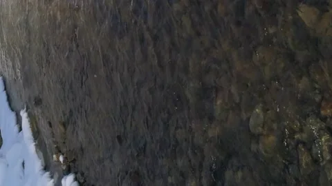 Vertical video. Flight over the flow of a winter mountain river. Stock-Footage 229548425