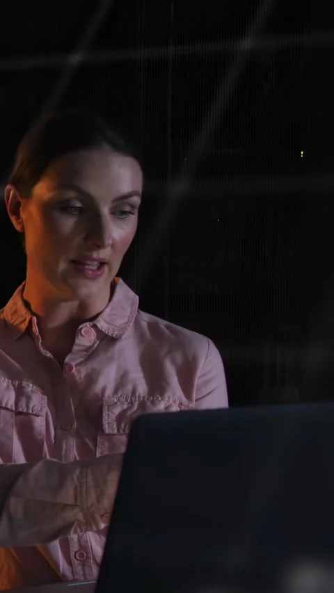 Vertical video: Floating text appearing, woman explaining tech data at laptop Stock Footage 332734538
