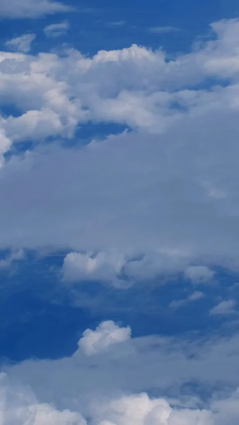 Vertical video from the flying airplane window on cumulus clouds Video stock 341375263