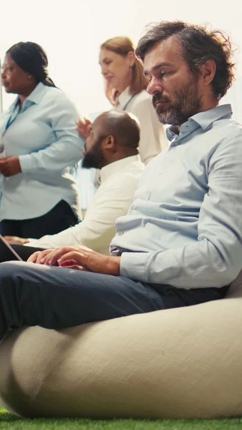 Vertical Video Focused businessman sitting and thinking about tasks on laptop Stock Footage 339070397