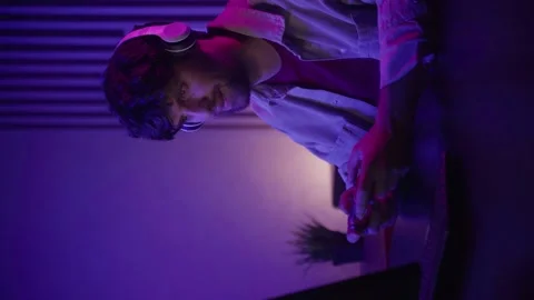 Vertical video: A focused individual is deeply immersed in gameplay, skillfully 스톡 동영상 282355449