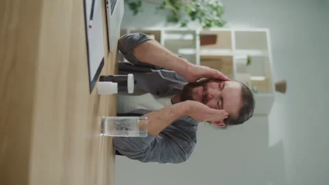 Vertical Video. Focused Man Work at a Table With a Laptop Suddenly Feeling Have Video stock 262113372