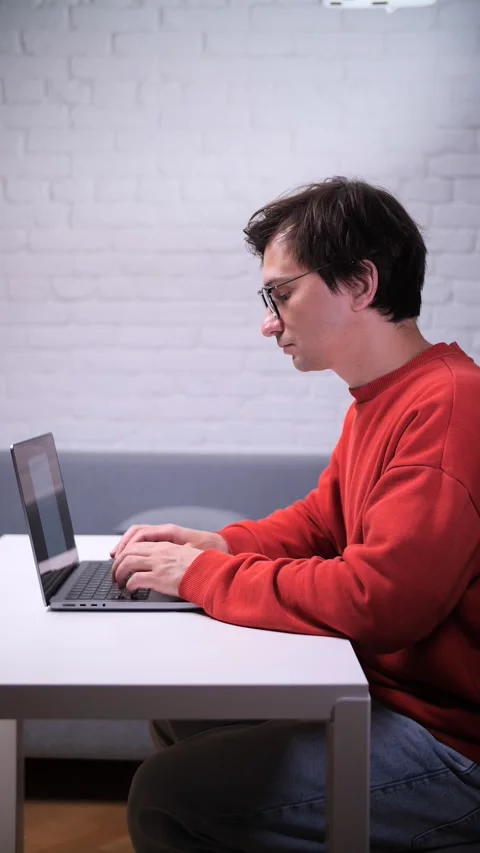 Vertical video Focused programmer working on laptop at home office Stock Footage 311202357