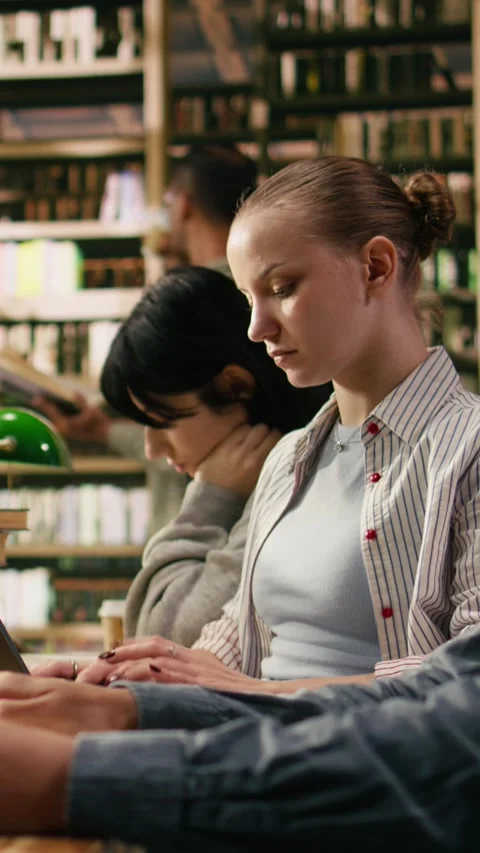 Vertical Video Focused student typing and taking notes on laptop for university Stock Footage 336378923