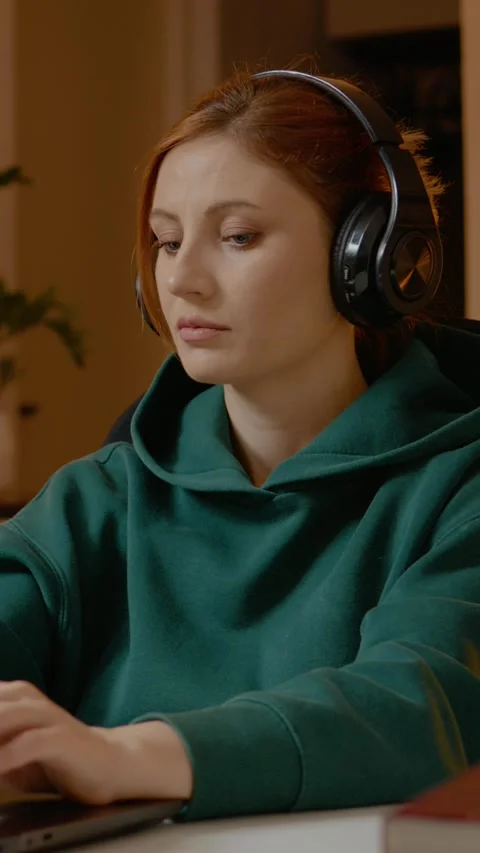Vertical video Focused young woman working from home on laptop with headphones Stock Footage 305138341