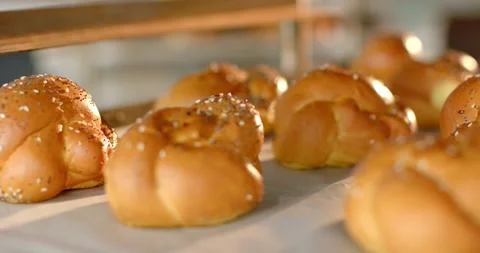 Vertical video: Focusing camera drawing braided rolls into sharp view on bakery 스톡 동영상 340965115
