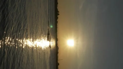 Vertical video footage, sunset reflection with silhouette of boat Stock Footage 141298736