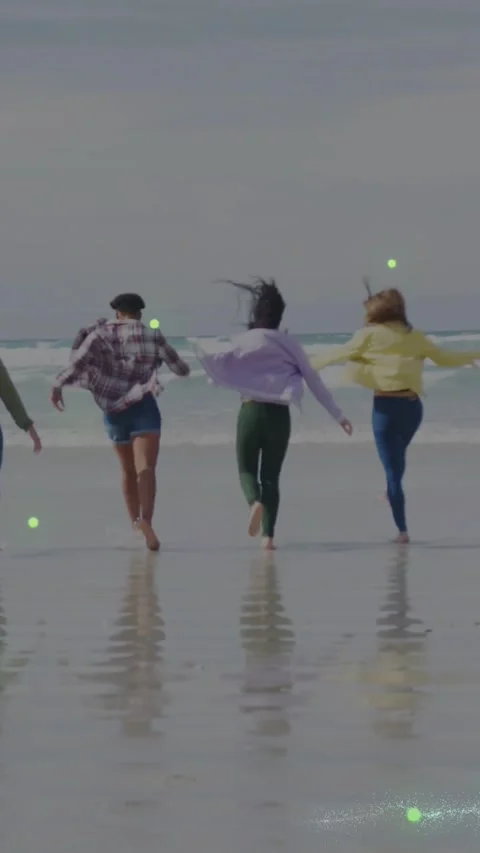 Vertical video: Four friends linking arms running toward sea while dots tracing Stock Footage 334550191
