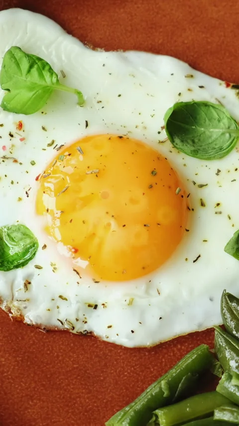 Vertical video. Fried egg and prepared green beans garnished with fresh bas.. Stock Footage 340333716