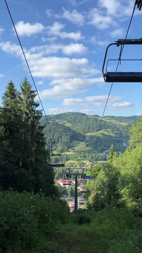 Vertical video of a funicular ascending a mountain through lush trees in summer Stock Footage 318953408