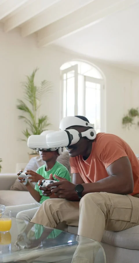 Vertical video: As game is starting dad and son are leaning, gripping VR Stock Footage 345129854