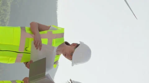 Vertical video. General plan people stand against background windmill electric Stock Footage 254112667