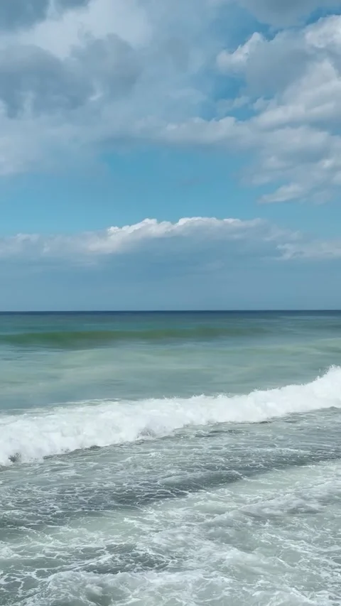 Vertical Video of Gentle Repeating Waves With Wooden Pier and Umbrellas in Clear Stock Footage 342302937