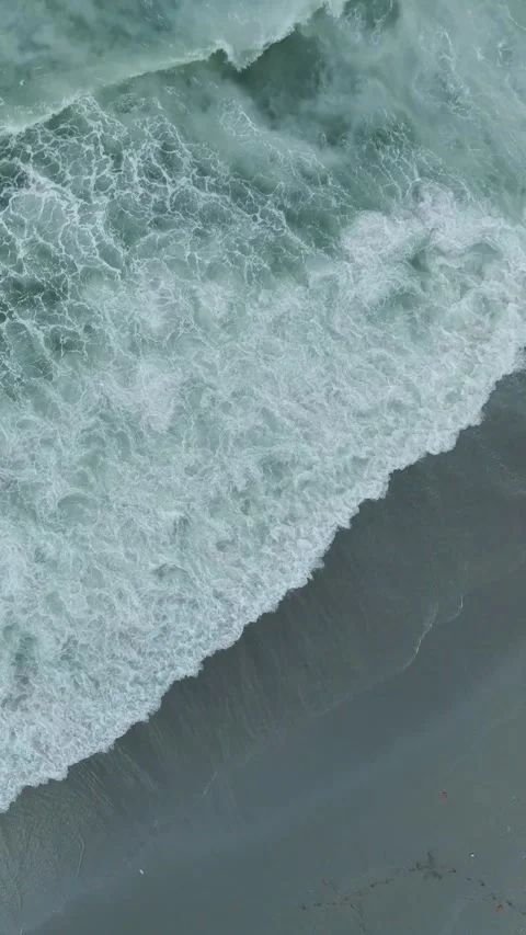 Vertical Video of Gentle Waves Rolling Beneath Wooden Pier With Umbrellas and Stock Footage 342303492