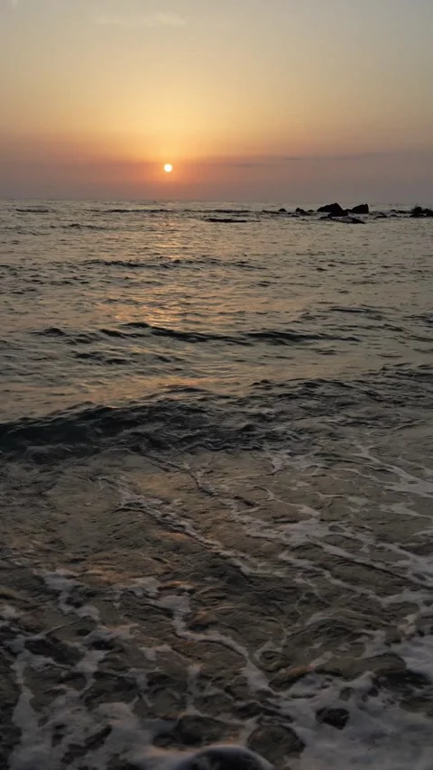 Vertical Video of Gentle Waves at Sunset on a Sandy Beach Stock-Footage 337733484