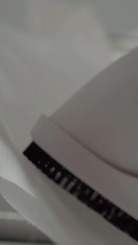 Vertical video Gently steaming delicate fabric to remove wrinkles for a polished Stock Footage 327598618