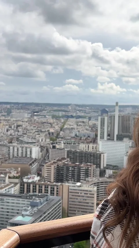 Vertical video girl on a eiffel tower looks around at the city of Paris visible Stock Footage 244253372
