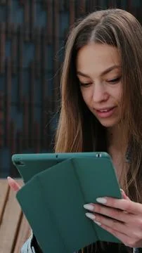 Vertical video. Girl Using Tablet Outdoors: Online Shopping and Booking on St Foto stock