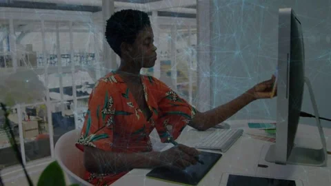 Vertical video: Glancing at screen, artist in orange checking swatch to screen Stock Footage 334039132