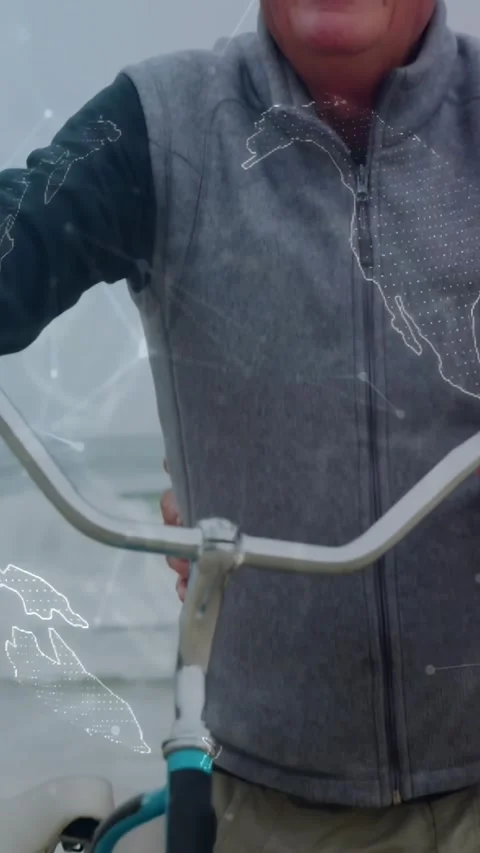 Vertical video: With globe overlay appearing, man holding bike looking up and Stock Footage 331405025
