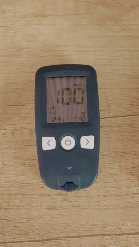 Vertical video Glucometer reading on wooden table shows blood sugar level at 100 Stock Footage 346714060