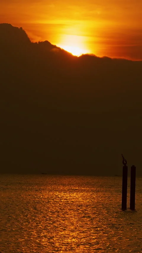 Vertical video. Golden Sunset Above Dark Clouds Over Calm Ocean With Passenger F Stock Footage 330543410